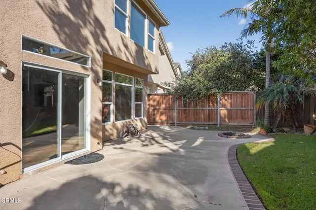 a view of a brick building with a yard and large tree