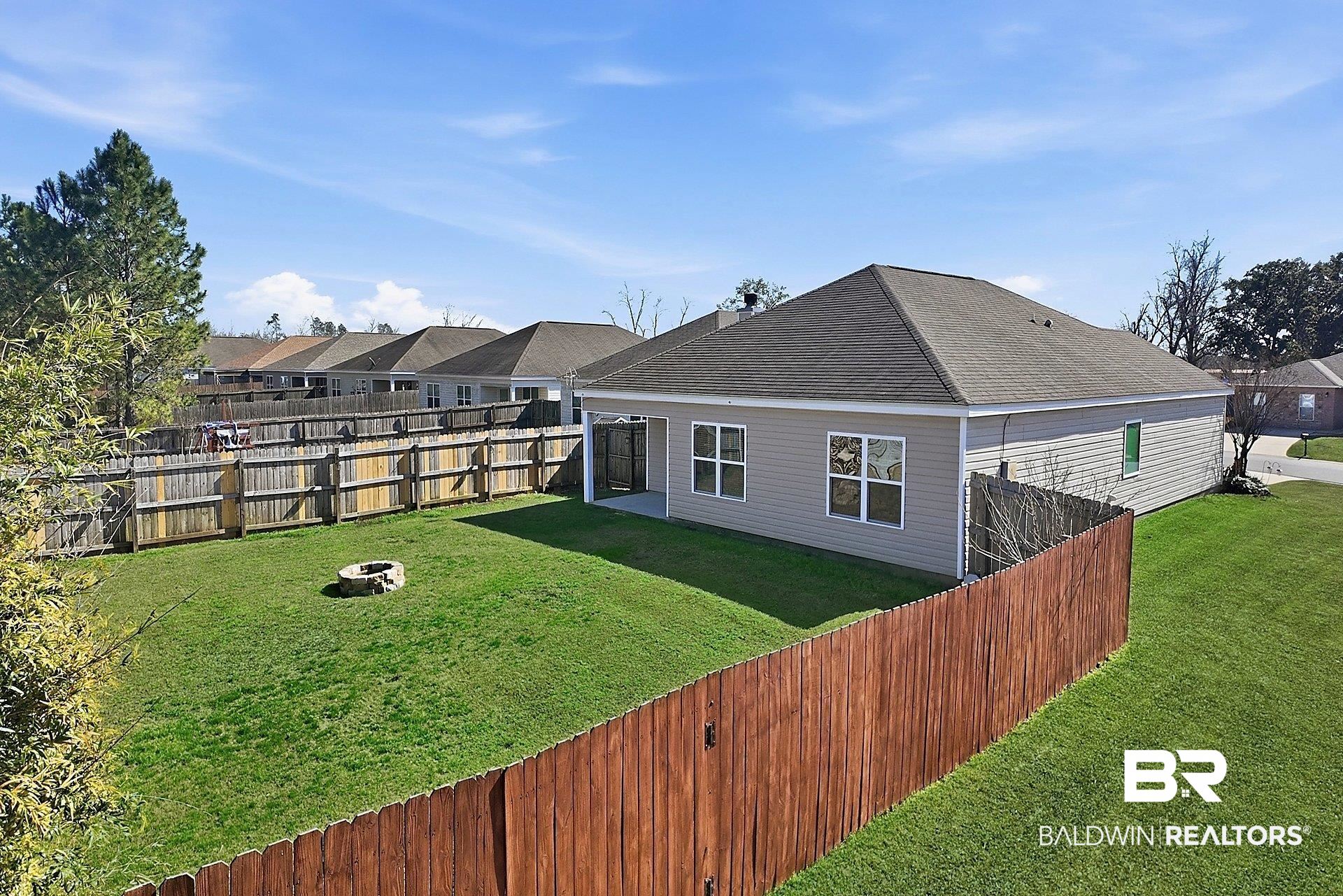 983 Summerton Drive Foley, AL 36535 - Photo 6 of 25 Rear view of property featuring an outdoor fire pit, a fenced backyard, a shingled roof, and a residential view