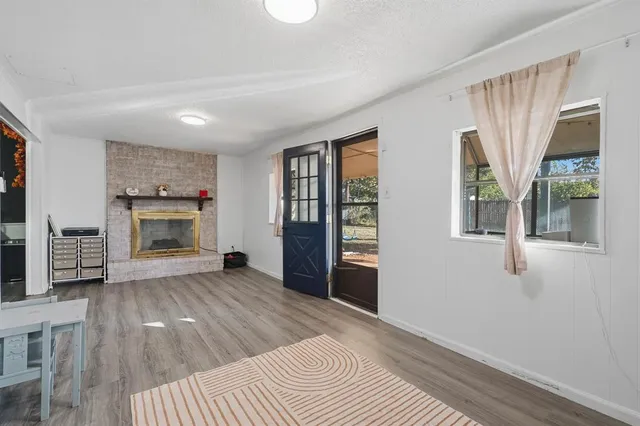 a view of an empty room with a window and fireplace