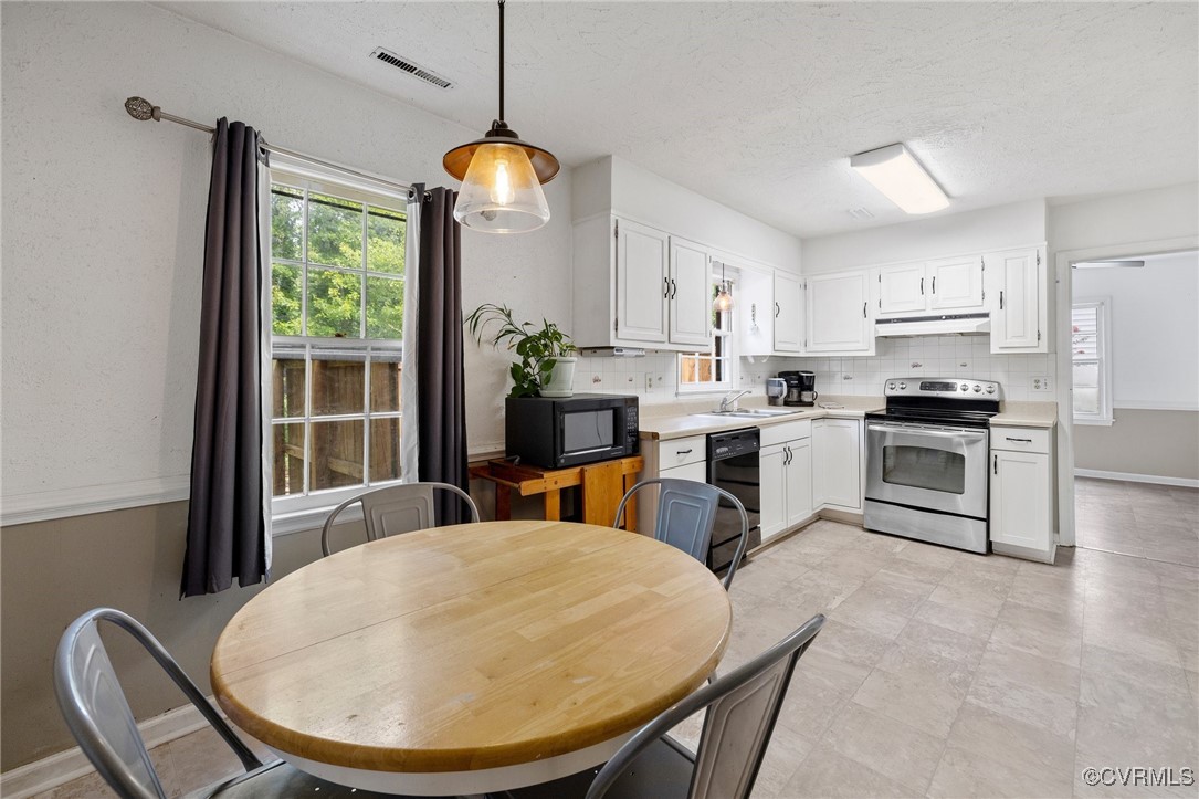 1908 Early Settlers Road Richmond, VA 23235 - Photo 5 of 25 a kitchen with kitchen island a stove a refrigerator a dining table and chairs next to a window