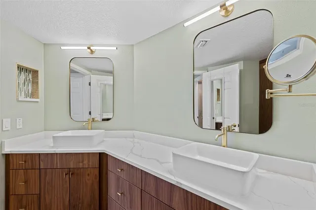 a bathroom with a sink a vanity a mirror and a mirror