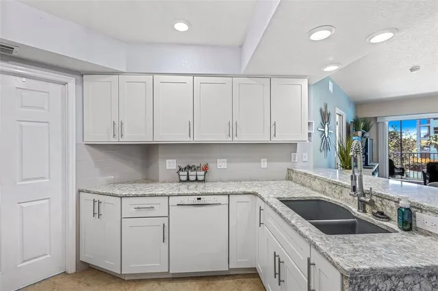 a kitchen with granite countertop a sink a stove and cabinets
