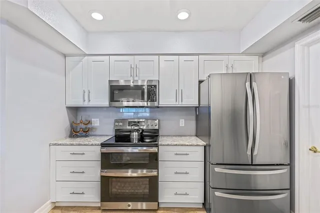 a kitchen with appliances a sink and cabinets
