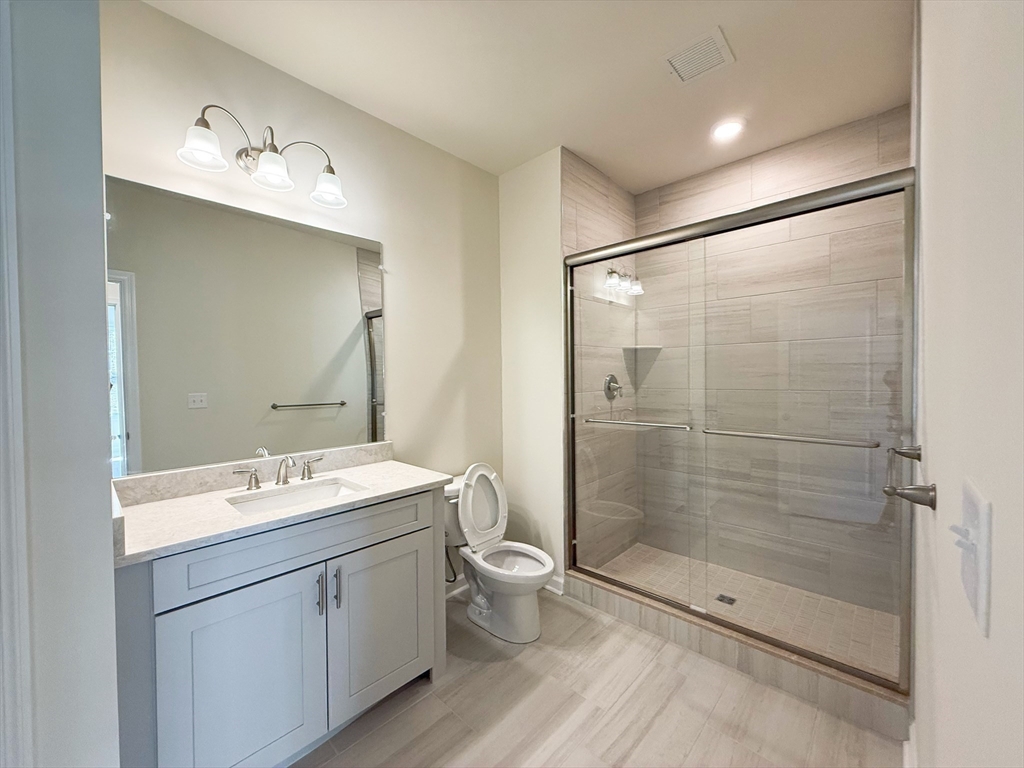 6 Stratton Drive, Unit 110 Woburn, MA 01801 - Photo 20 of 26 a spacious bathroom with a shower sink mirror and toilet