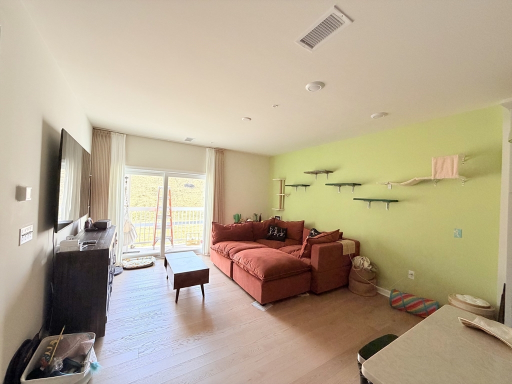 6 Stratton Drive, Unit 110 Woburn, MA 01801 - Photo 2 of 26 a living room with furniture and a flat screen tv