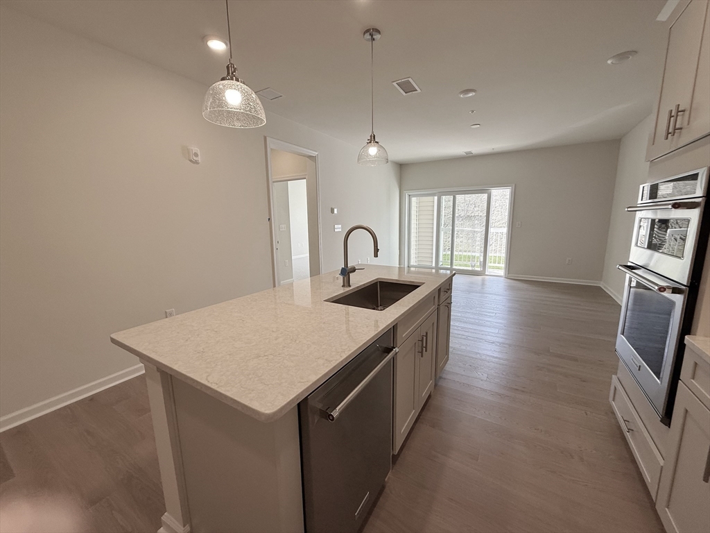 6 Stratton Drive, Unit 110 Woburn, MA 01801 - Photo 4 of 26 a kitchen with sink a refrigerator and wooden floor