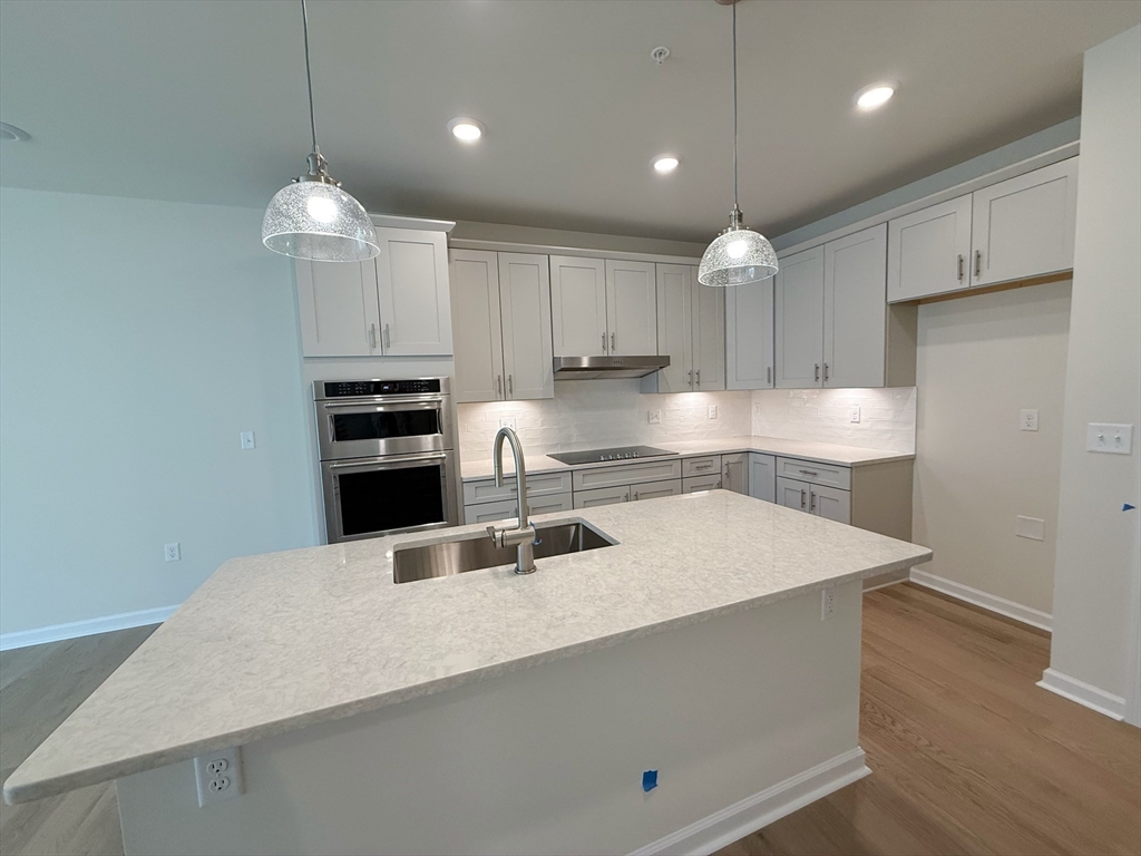 6 Stratton Drive, Unit 110 Woburn, MA 01801 - Photo 9 of 26 a kitchen with kitchen island a sink stainless steel appliances and cabinets