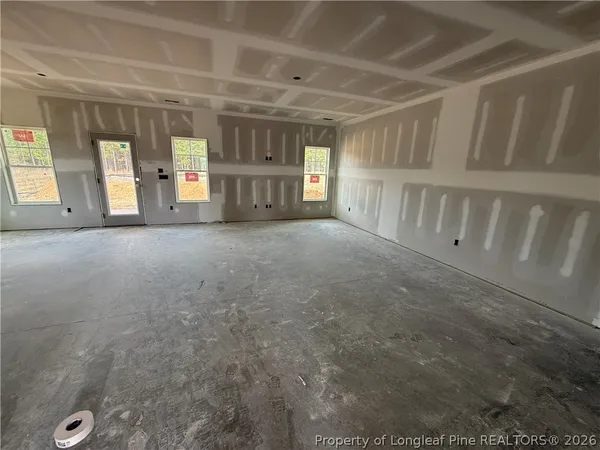 a view of empty room with wooden floor and windows
