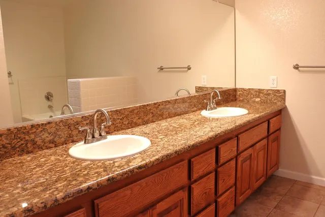 a bathroom with a granite countertop sink and a mirror
