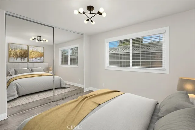 a bedroom with a large bed and two window