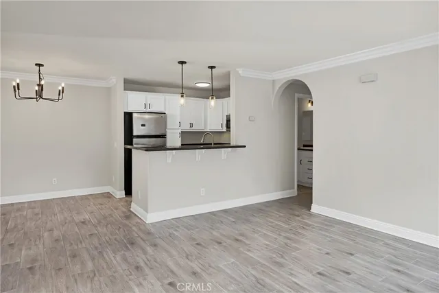 a kitchen with stainless steel appliances granite countertop a sink a oven and a refrigerator with wooden floor