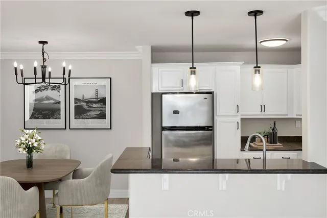 a kitchen with stainless steel appliances granite countertop a refrigerator a sink and a stove