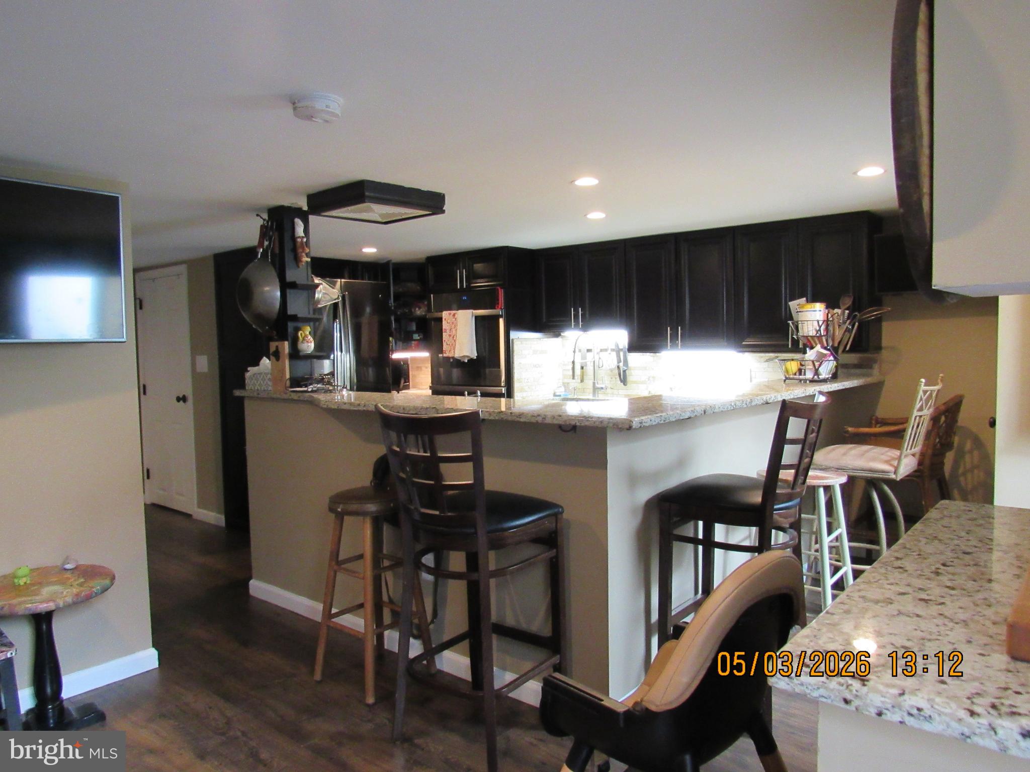 1276 Stump Hall Road Collegeville, PA 19426 - Photo 32 of 46 a kitchen with stainless steel appliances kitchen island granite countertop a table chairs sink and cabinets