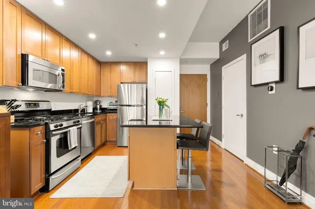 a kitchen with stainless steel appliances granite countertop wooden cabinets a stove top oven a sink and dishwasher