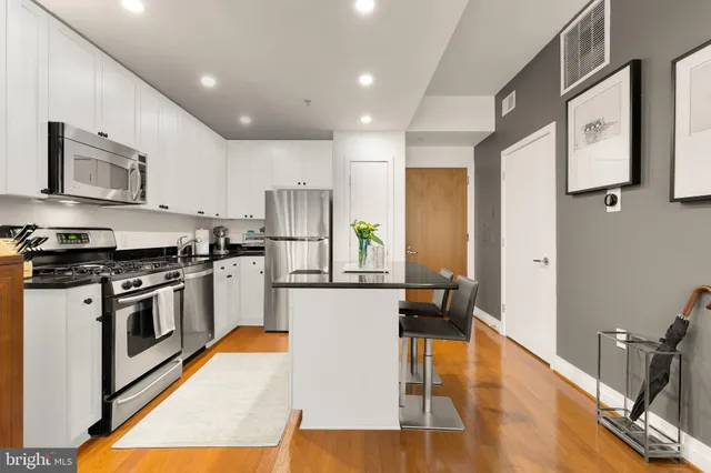 a kitchen with stainless steel appliances granite countertop a stove a refrigerator and a refrigerator