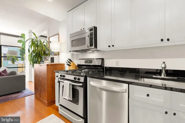 a kitchen with granite countertop white cabinets and stainless steel appliances