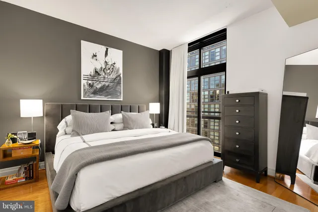 a bedroom with a bed and a flat tv screen on dresser