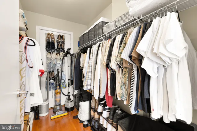 a view of walk in closet with clothes and shoes