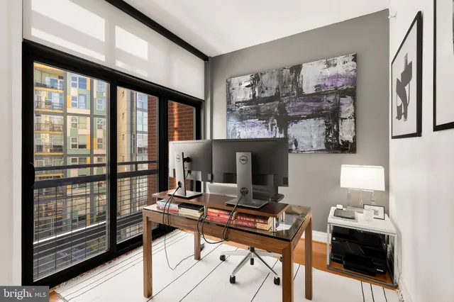 a view of a workspace with furniture and a window