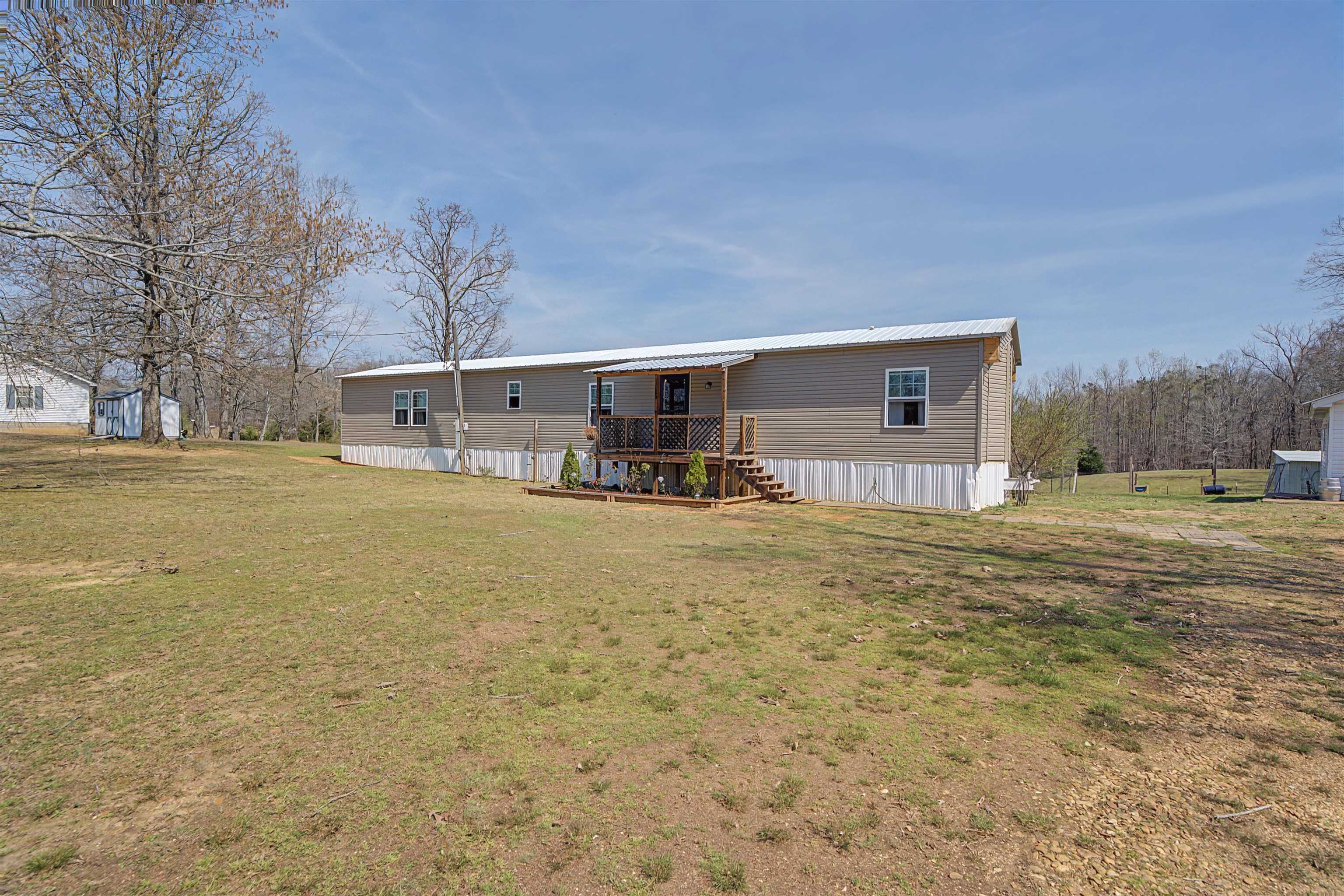 7010 22nd Highway Adamsville, TN 38310 - Photo 1 of 33 Back of property featuring a lawn and a metal roof