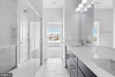 a bathroom with a granite countertop sink a large mirror and a shower