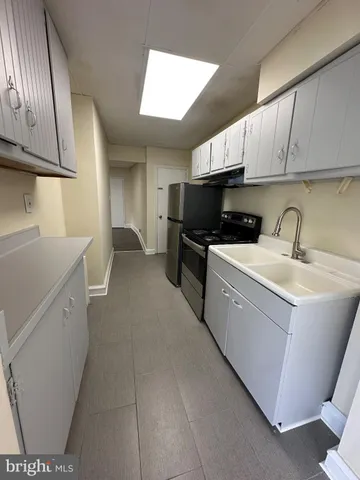 a kitchen with a sink a microwave and cabinets