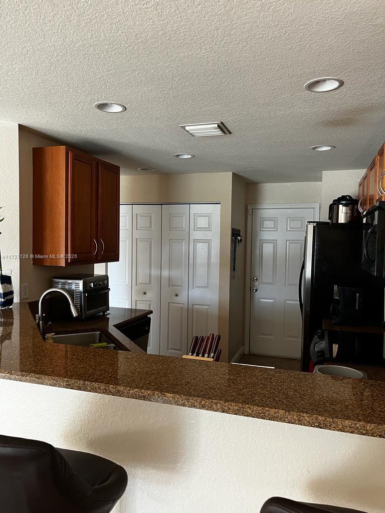 5923 Abbey Road Tamarac, FL 33321 - Photo 11 of 37 a kitchen with stainless steel appliances granite countertop a sink and a refrigerator