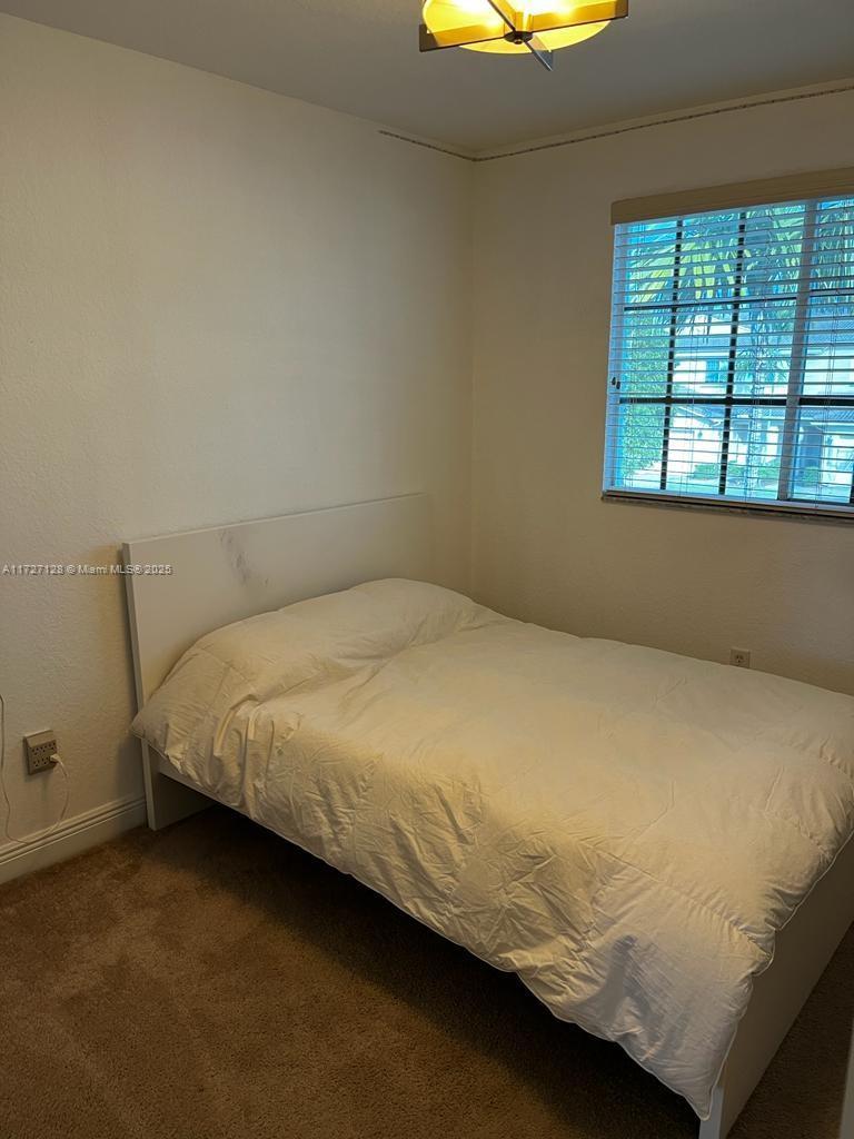 5923 Abbey Road Tamarac, FL 33321 - Photo 17 of 37 a bed sitting in a bedroom next to a window