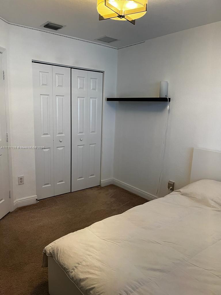 5923 Abbey Road Tamarac, FL 33321 - Photo 18 of 37 a bedroom with a bed and cabinets