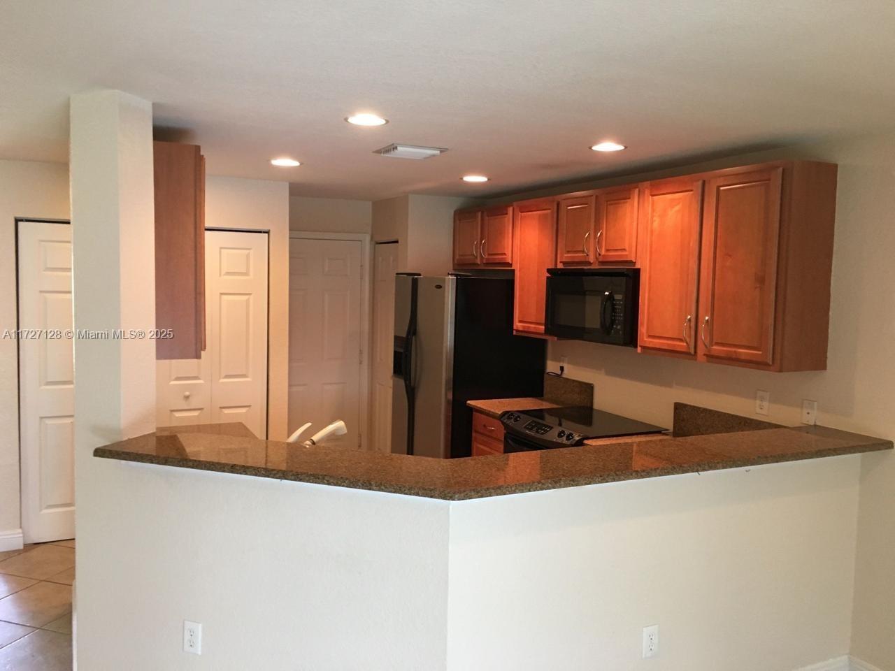 5923 Abbey Road Tamarac, FL 33321 - Photo 9 of 37 a kitchen with stainless steel appliances granite countertop a sink and a refrigerator