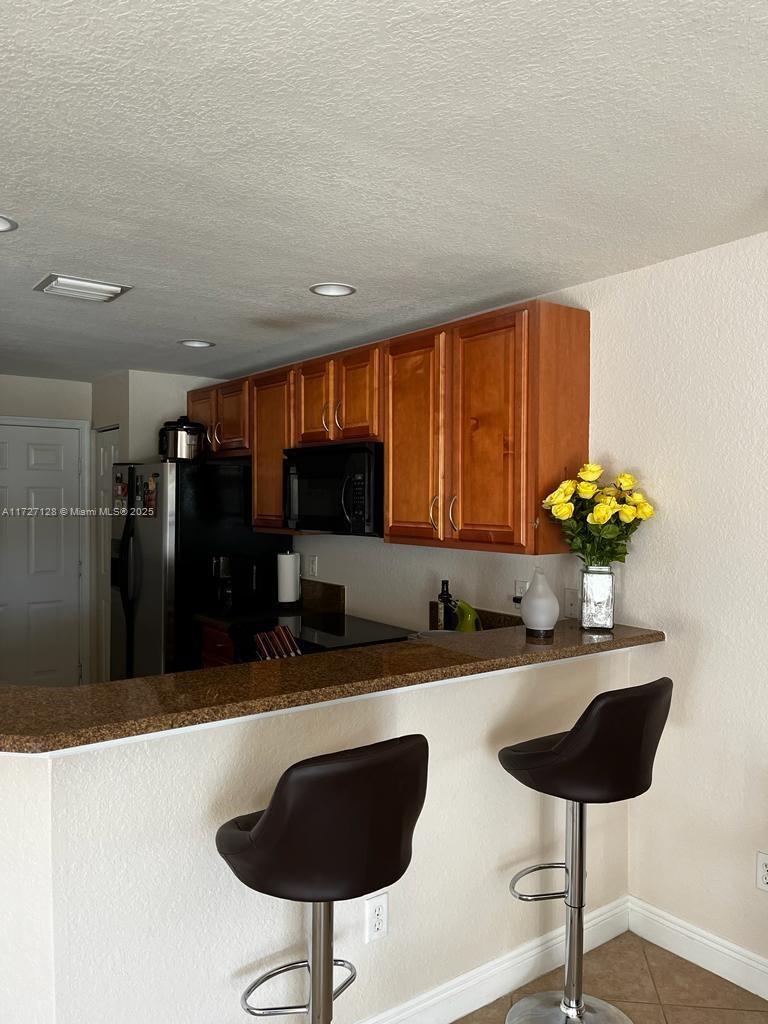 5923 Abbey Road Tamarac, FL 33321 - Photo 10 of 37 a kitchen with stainless steel appliances a sink a stove a refrigerator a dining table and chairs