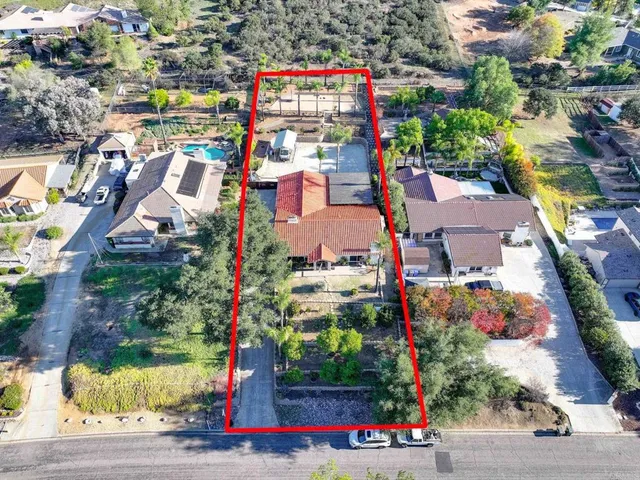 an aerial view of residential house with yard and mountain view in back