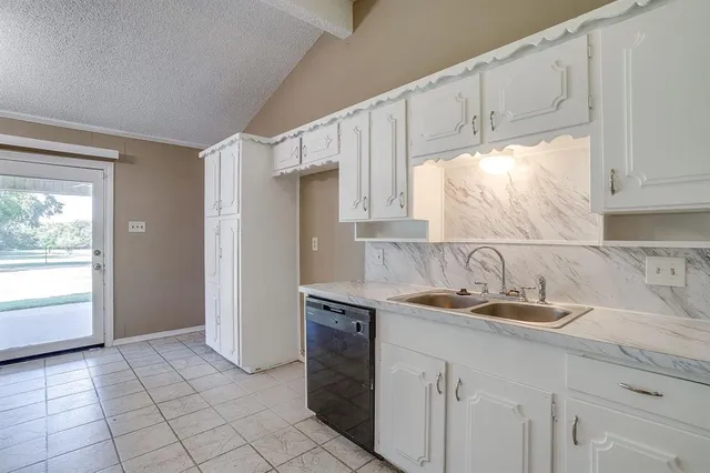 a kitchen with kitchen island granite countertop a sink cabinets and a refrigerator