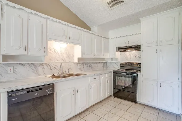 a kitchen with a sink stove and cabinets