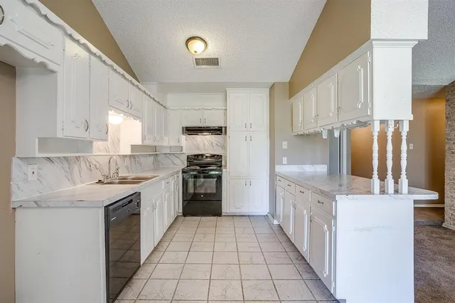 a kitchen with stainless steel appliances granite countertop a refrigerator and a stove