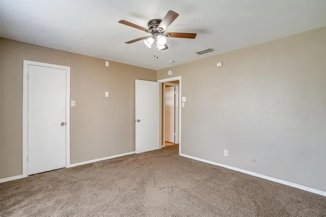 an empty room with a window and a ceiling fan