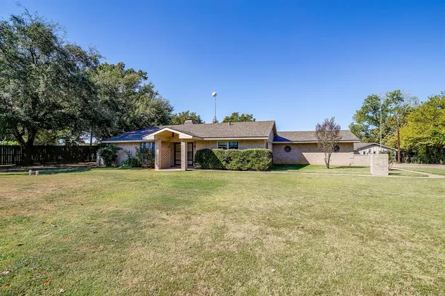 a front view of a house with a garden and parking