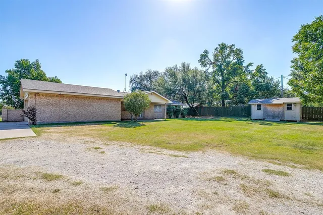a front view of a house with a yard and tree s