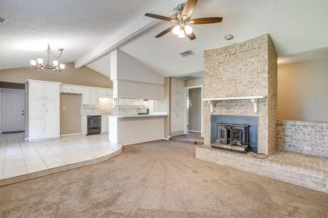 a view of a livingroom with a fireplace a ceiling fan a fireplace and windows