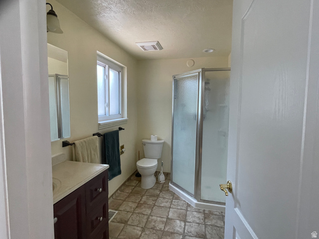 438 East Main Street Elsinore, UT 84724 - Photo 30 of 43 Bathroom featuring a glass-enclosed shower, a vanity with a light-colored countertop, and a window with white trim