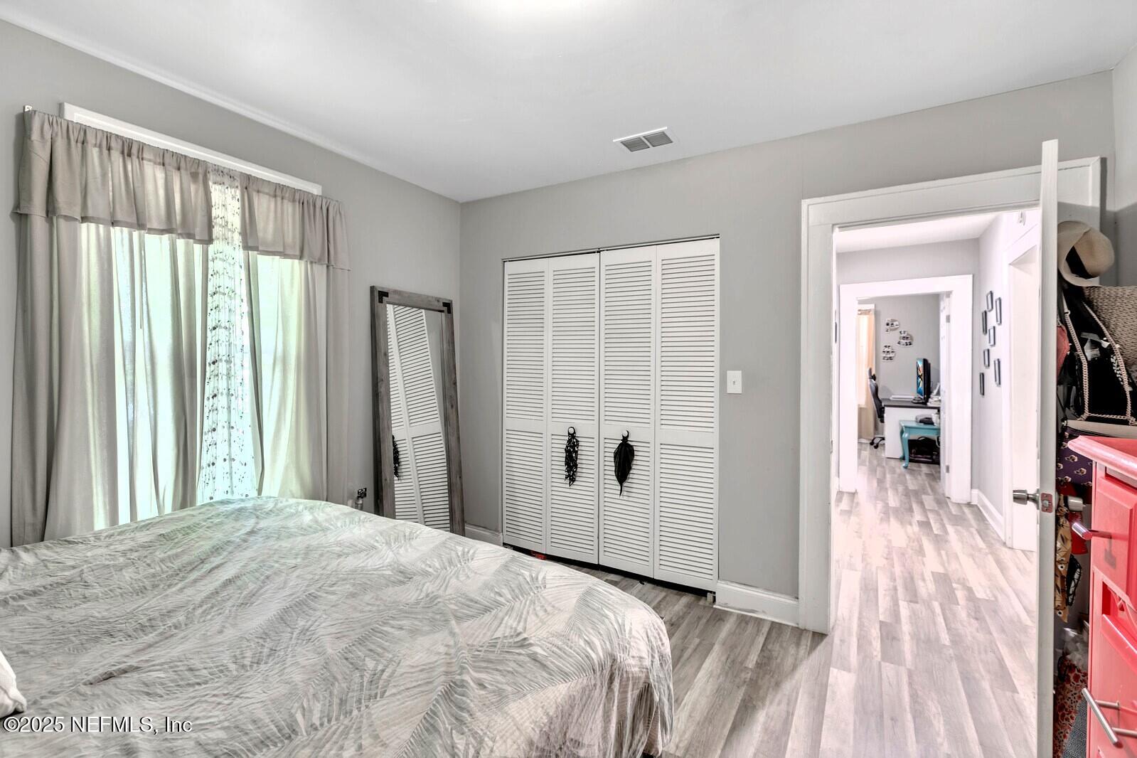 1336 Rushing Street Jacksonville, FL 32209 - Photo 8 of 19 a view of a bedroom with wooden floor and windows