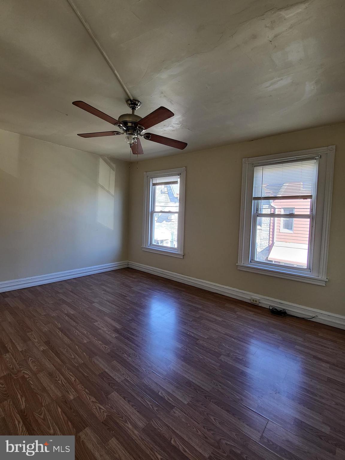 830 Church Street Reading, PA 19601 - Photo 5 of 12 an empty room with wooden floor chandelier fan and windows