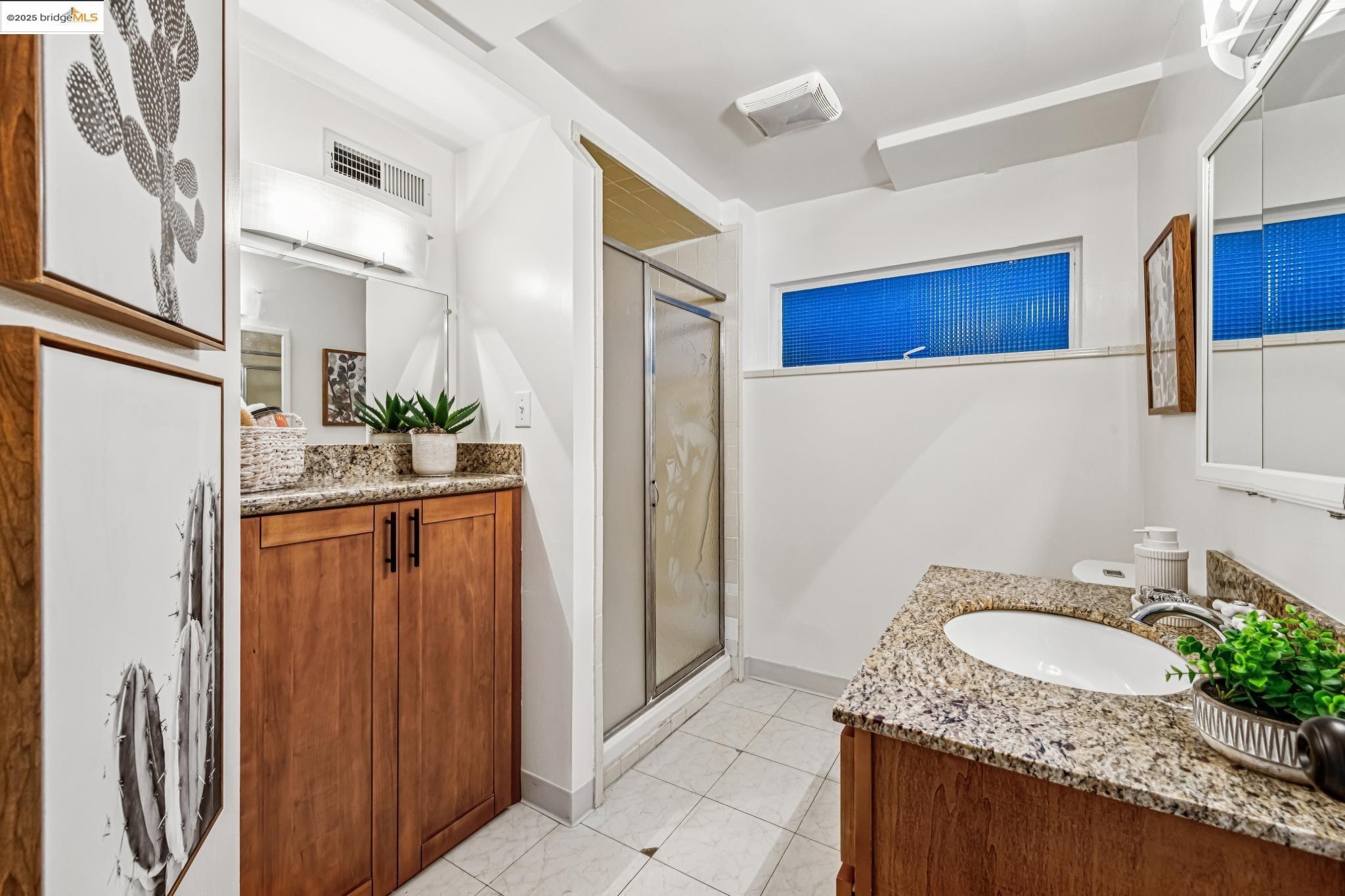 946 Creston Road Berkeley, CA 94708 - Photo 22 of 44 a bathroom with a granite countertop sink and a mirror