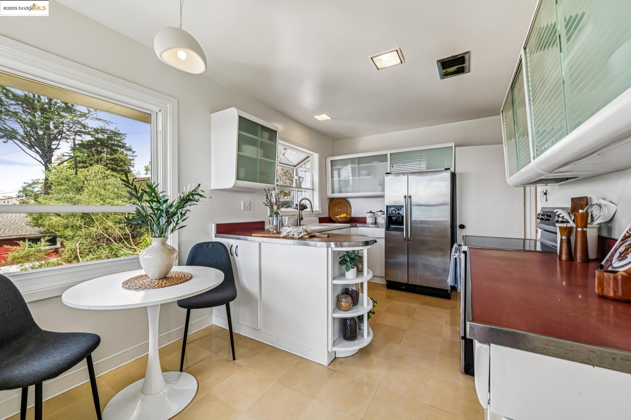 946 Creston Road Berkeley, CA 94708 - Photo 9 of 44 a living room with furniture a dining table and a refrigerator