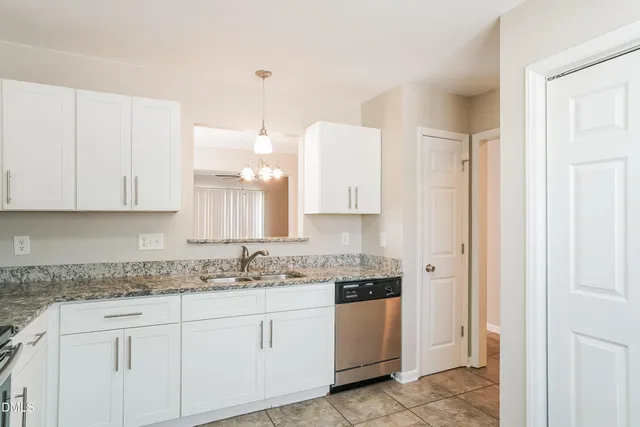 a kitchen with granite countertop white cabinets white stainless steel appliances with a sink and dishwasher