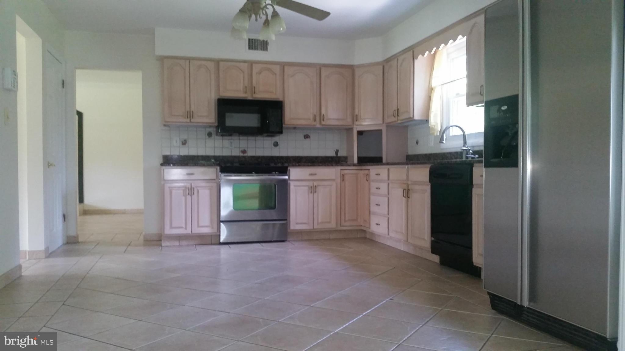 2119 Pot Spring Road Lutherville-Timonium, MD 21093 - Photo 4 of 30 a large kitchen with cabinets and a fireplace