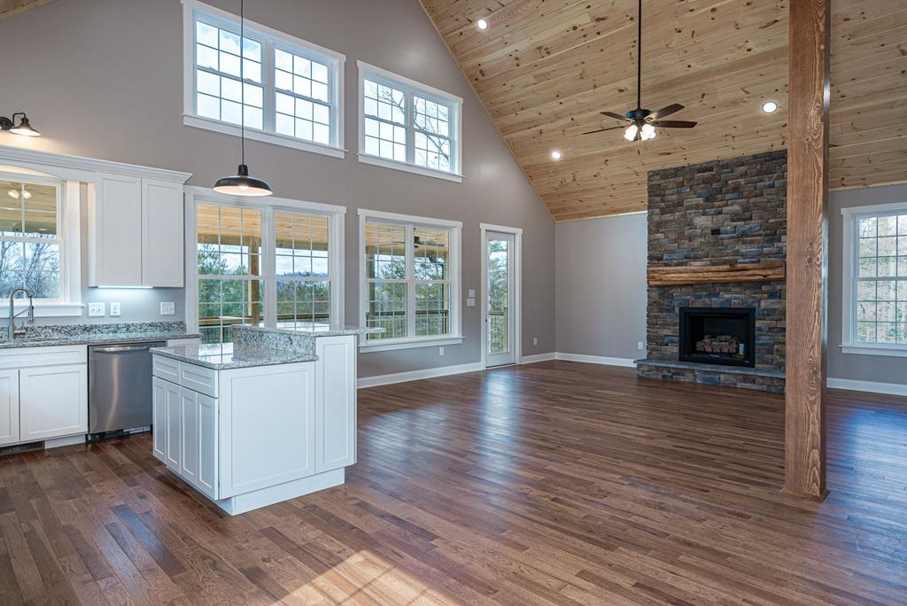 259 River Mountain Road Murphy, NC 28906 - Photo 17 of 42 wooden floor in an empty room with a kitchen and a fireplace