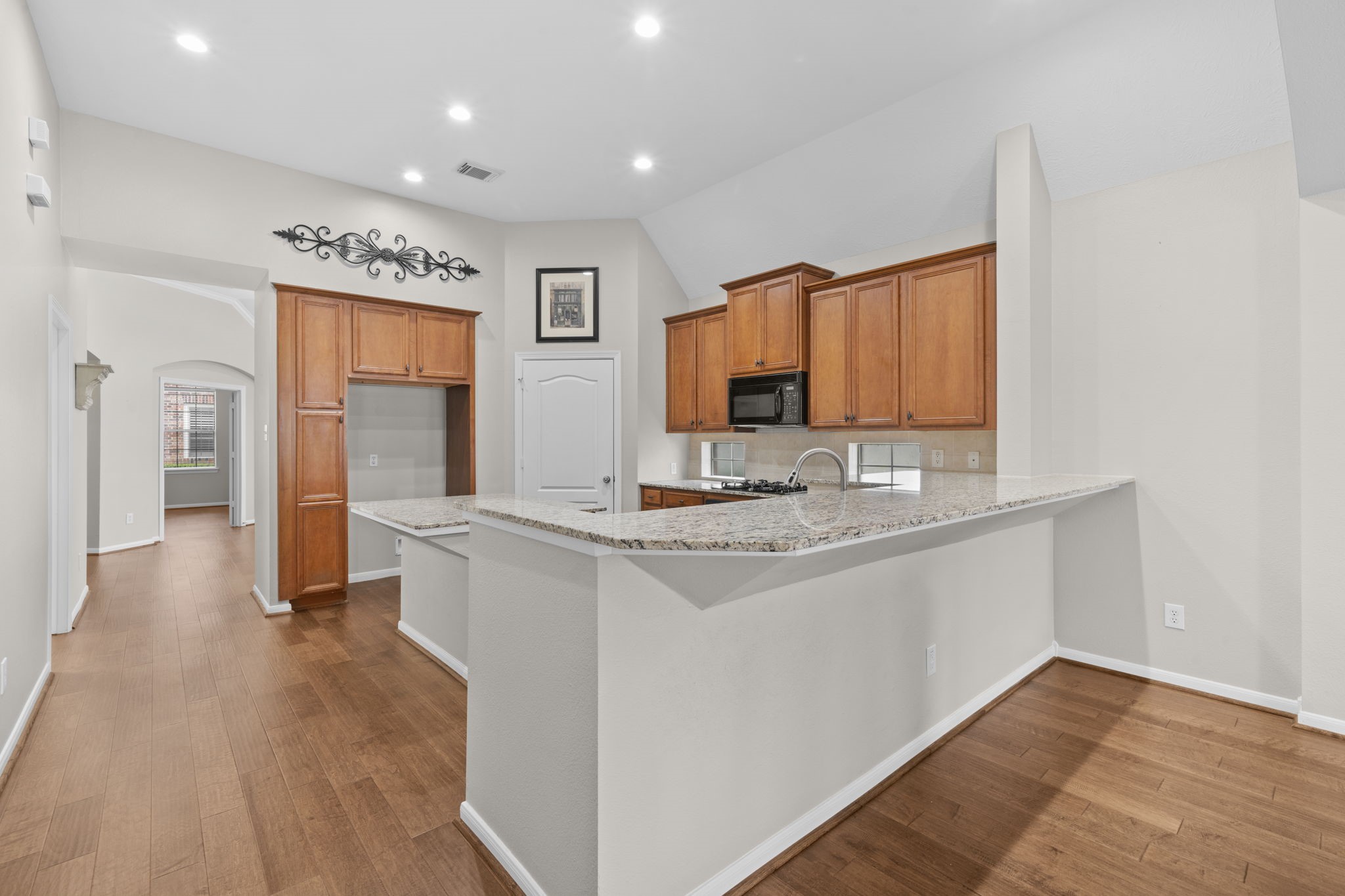 226 Whispering Ridge Terrace Houston, TX 77094 - Photo 8 of 31 a kitchen with kitchen island granite countertop a sink cabinets and wooden floor