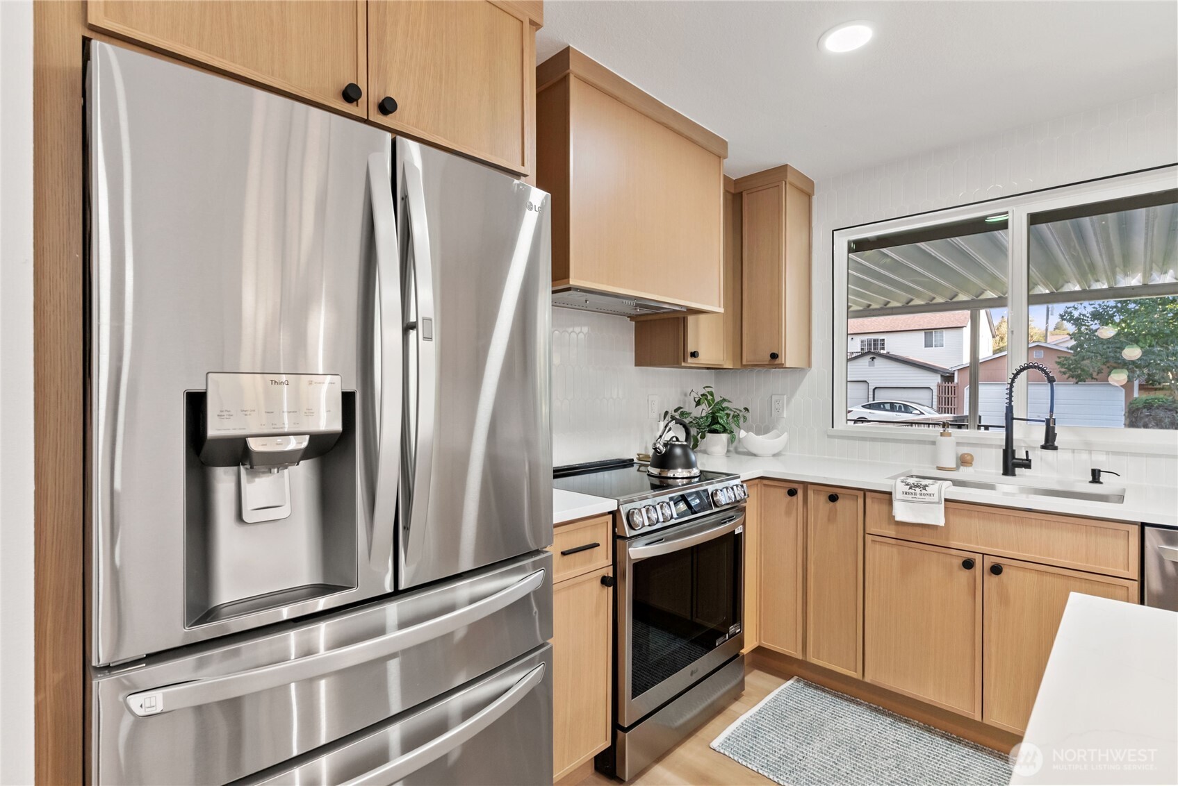 9548 3rd Avenue Northwest Seattle, WA 98117 - Photo 15 of 40 a kitchen with white cabinets and stainless steel appliances