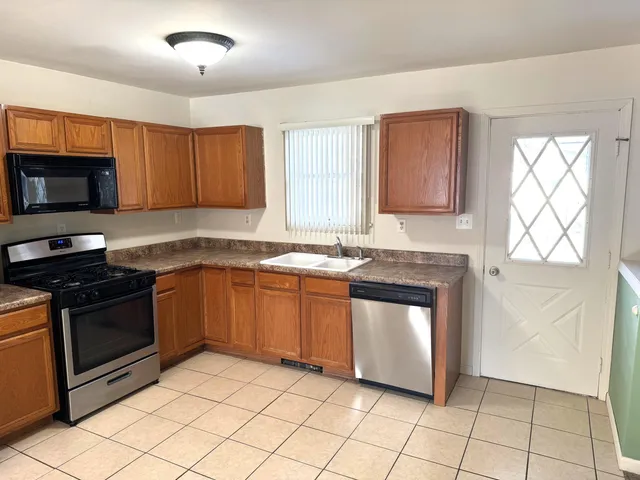 a kitchen with stainless steel appliances granite countertop a stove a sink and a microwave